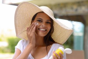 Woman applying sunscreen to her face.