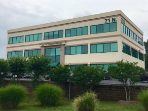 Three-story office building with green-tinted windows, labeled "High Tide Offices of Annapolis."