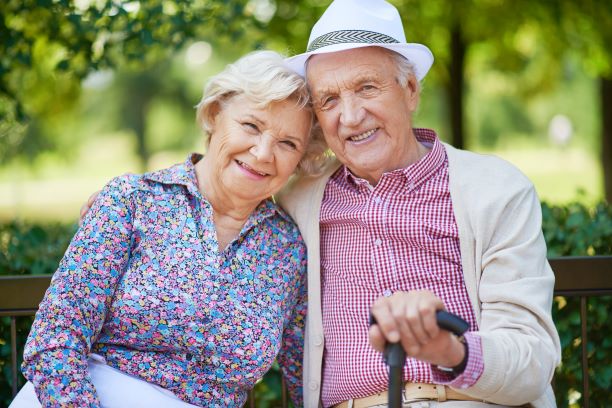 couple with aging skin sitting on park bench