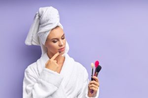 Woman considering cleaning makeup brushes
