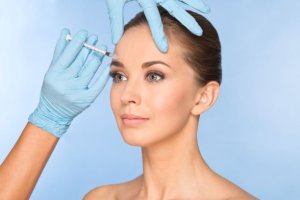 Woman receiving botox injection in forehead