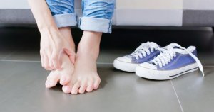 Woman scratches rash on feet