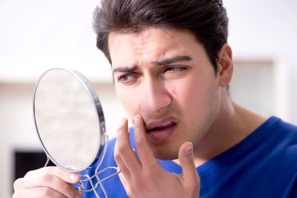 Man examines face for skin cancer