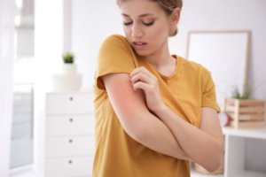 woman scratches eczema from irritants in her home