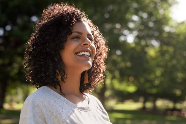 Woman in the sun wonders "Does the sun help acne?"