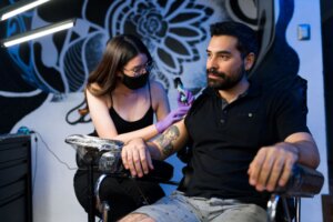 Man with psoriasis and tattoos getting a new tattoo