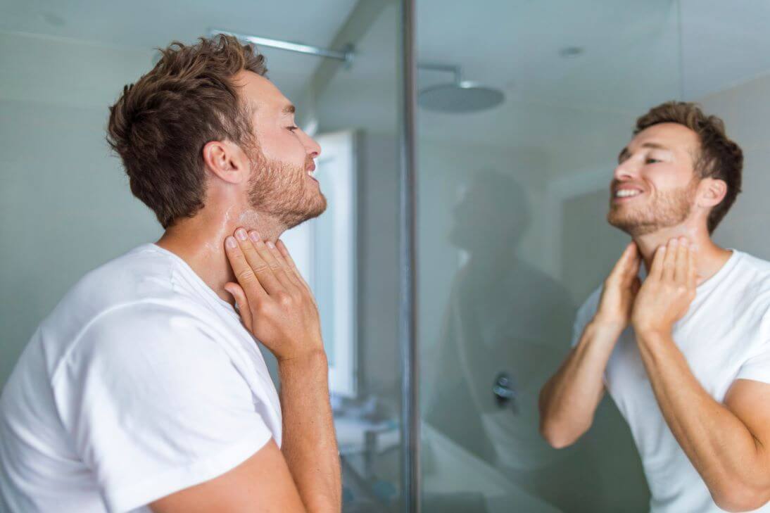 Man looking at folliculitis on neck in the mirror