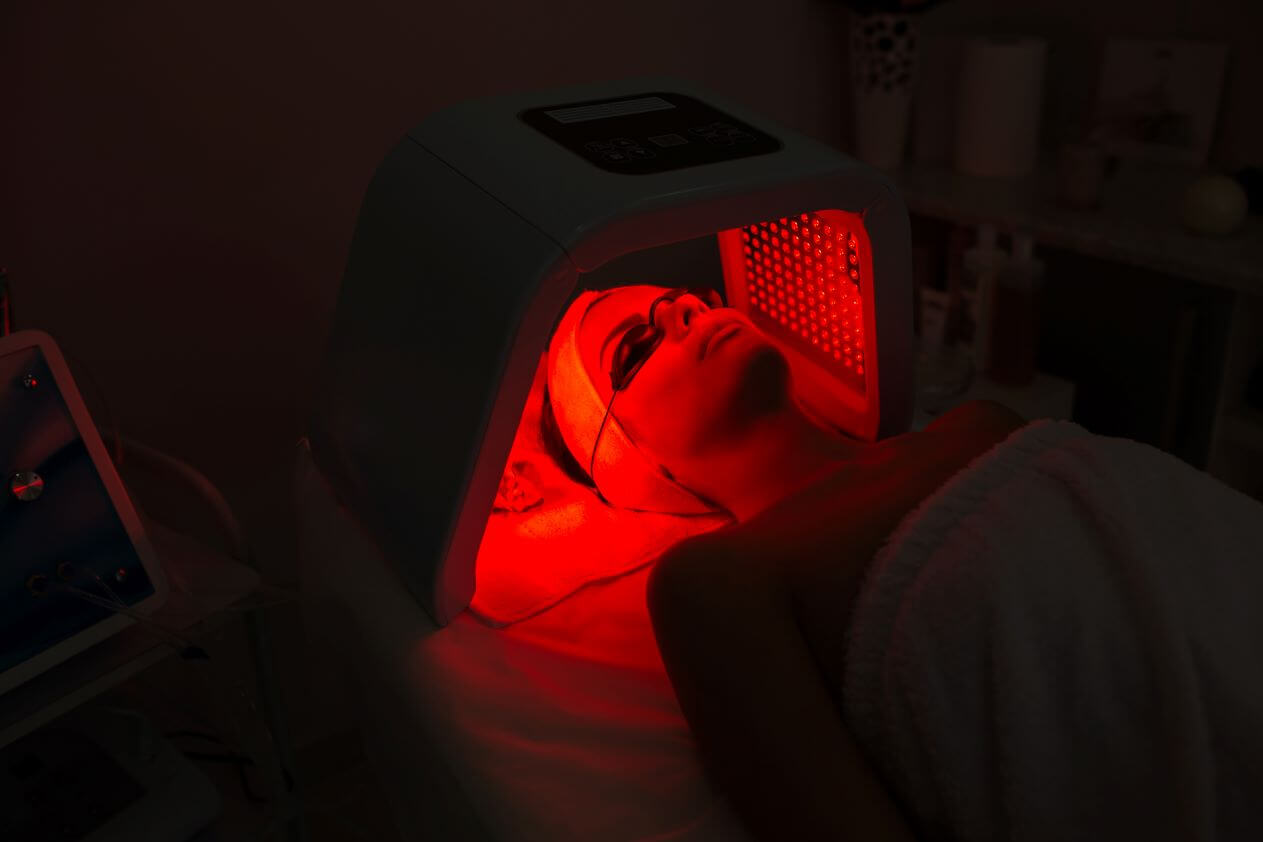 Woman undergoing red light therapy.