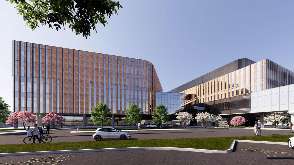 A modern architectural rendering of a large building complex with glass facades, trees, and a roadway.